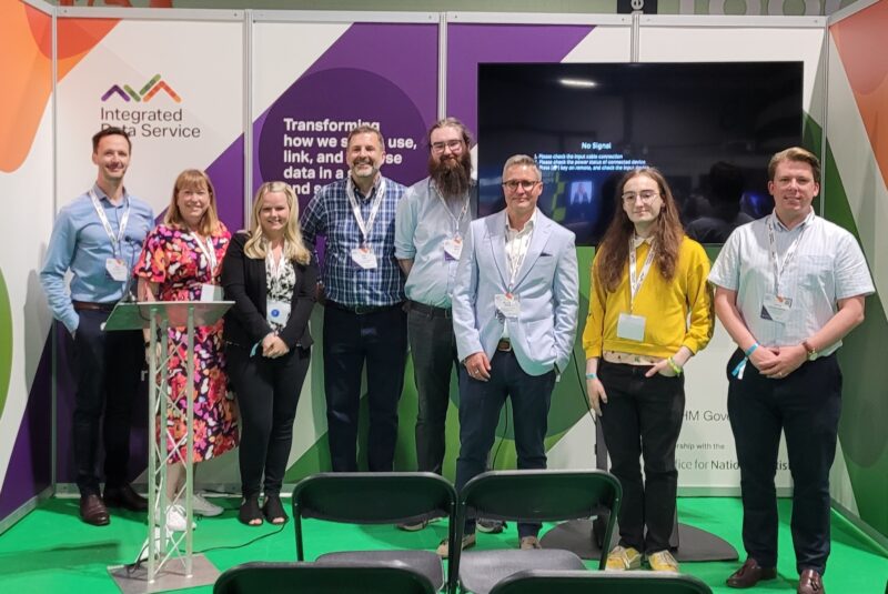 The Integrated Data Service team stood in front of the stand at Civil Service Live